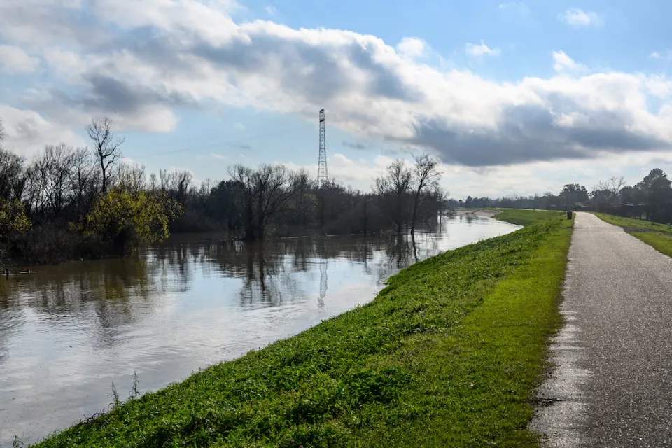 Paved bike path on top of earthen dike levee along Mississippi River in Louisiana.
